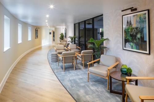 a waiting room at a hospital with chairs and tables at Holiday Inn Gloucester - Cheltenham by IHG in Gloucester