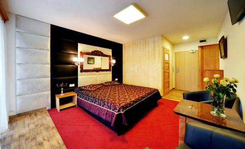 a hotel room with a bed and a red carpet at Hotel SZKLARSKA PORĘBA in Szklarska Poręba