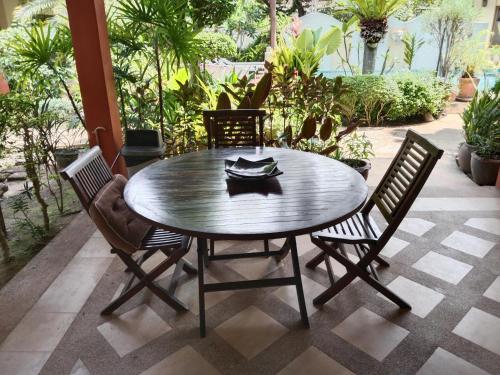 a wooden table and chairs on a patio at Baan Tropicana in Mae Nam