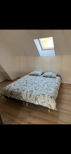 un lit dans une chambre avec une fenêtre dans l'établissement La grange, à Anglesqueville-la-Bras-Long