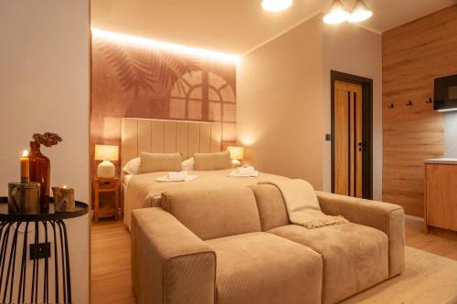 a large bedroom with a bed and a couch at STING Boutique Apartments in Ostrava