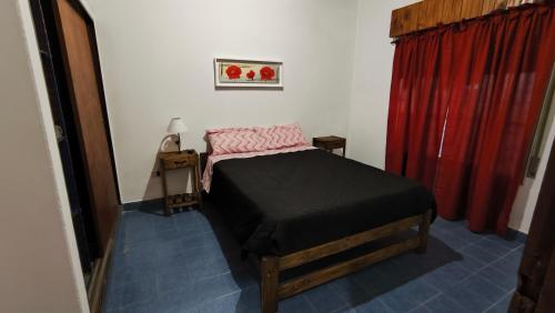 une chambre avec un lit et un rideau rouge dans l'établissement Cabaña de 1 habitacion en el centro de Choele ideal para 2 personas, à Choele Choel