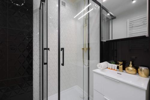 a shower with a glass door in a bathroom at Wyjątkowy Apartament dla 4 osób by Noclegi Renters in Pruszków