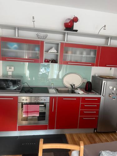 Una cocina con gabinetes rojos y un fregadero. en Bjelasnica, en Babin Do