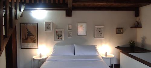 una camera con un letto e due luci su due tavoli di La Casetta degli Innamorati a Sutri