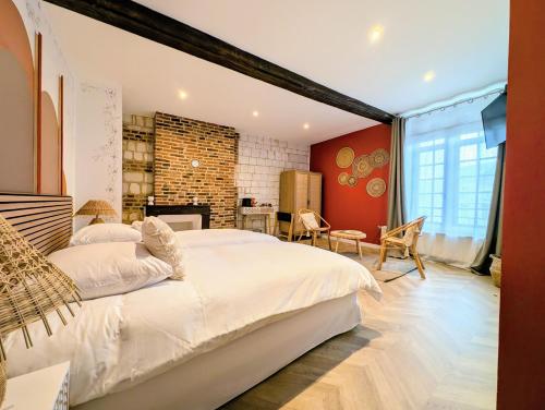 a bedroom with a large bed and a brick wall at Le Relais du Beffroi & SPA in Saint-Riquier