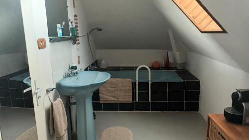 a bathroom with a blue sink and a tub at La Petite Ecole de la Baie in Pontorson