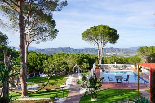 an estate with a swimming pool and mountains in the background at Apartamentos Dos Carneros in Alhaurín de la Torre