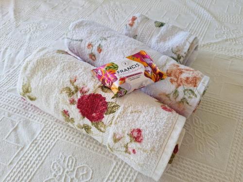 a group of towels with flowers on them on a bed at Pousada Recanto Barão de Biguaçu in Biguaçu