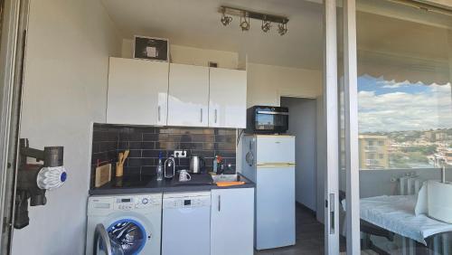 une cuisine avec un lave-linge et un réfrigérateur dans l'établissement Charmant studio avec parking, à Cagnes-sur-Mer