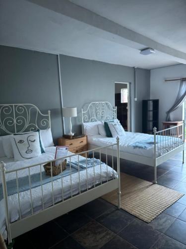 a bedroom with two beds and a table with a lamp at Buckswood Hilltops in Stegi