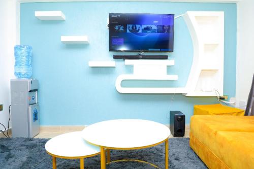 a living room with a tv on a blue wall at Christabell in Kisii
