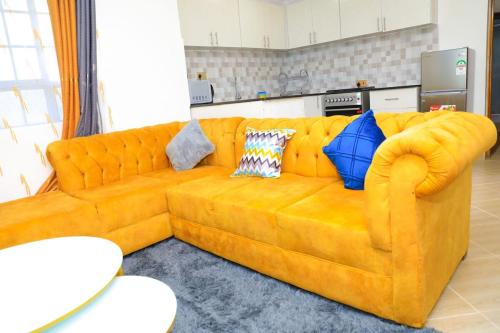 a large yellow couch in a living room at Christabell in Kisii