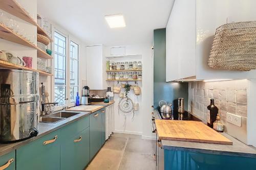 une cuisine avec des armoires bleues et un comptoir dans l'établissement Charming apartment near Sacrée Coeur, à Paris