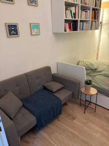 a living room with a couch and a table at Maison de ville paisible in Lormont