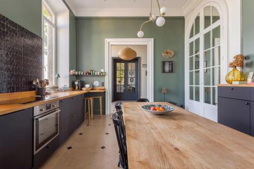 - une cuisine avec une grande table en bois dans l'établissement Hamac Suites - L'Époustouflante, à Sainte-Foy-lès-Lyon
