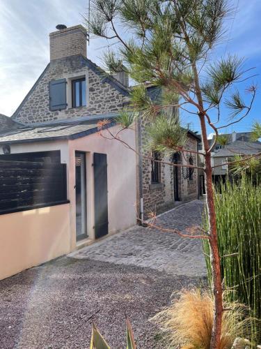 une maison avec un pin devant elle dans l'établissement Villa de Caractère avec Piscine, à Saint-Malo