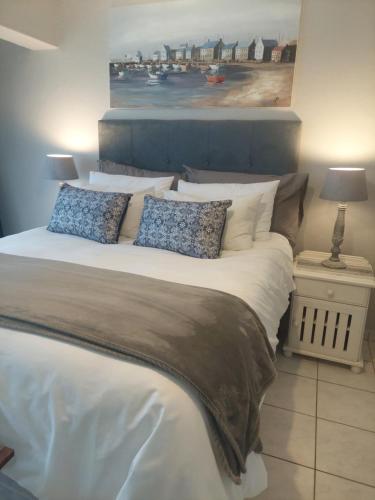 a large bed with pillows and a painting on the wall at Nomads Nook 15 in Ramsgate