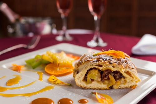 a white plate with a pastry on a table with wine glasses at Hostal de la Luz - Spa Holistic Resort in Tepoztlán
