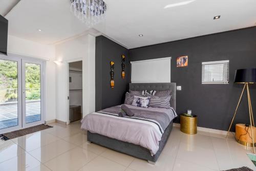 a bedroom with a bed and a black wall at Bed and Breakfast Villa Livadia in Cape Town