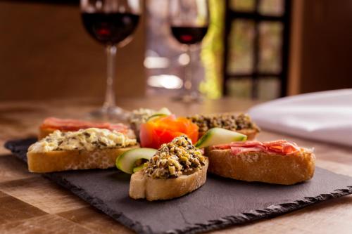 a plate of food with bread and vegetables and a glass of wine at Hostal de la Luz - Spa Holistic Resort in Tepoztlán