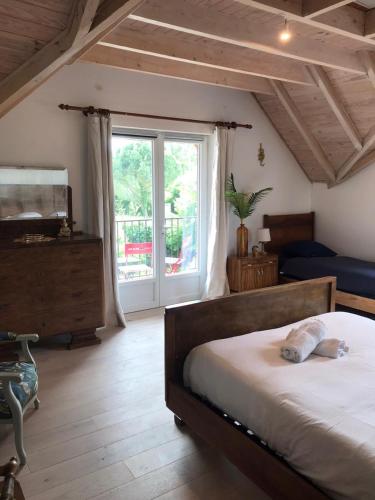 une chambre avec un lit et une grande fenêtre dans l'établissement Hameau entier: piscine et discothèque privatives !, à Le Lys-Saint-Georges
