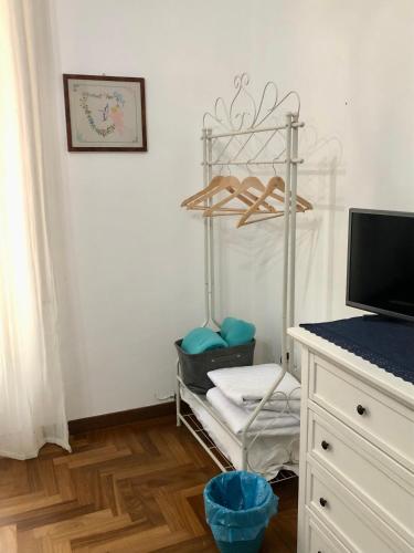 a room with a chair and a desk with a tv at G&G ROOMS in Palermo