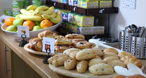 a counter with different types of pastries and fruit at Best Western Northfields Ealing Hotel in London