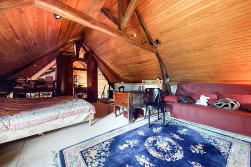 a bedroom with a bed and a couch in a attic at Maison de Campagne Les Loges de Brenne in Ardentes