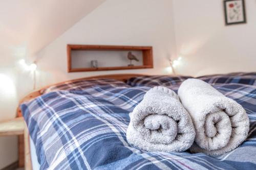 a bed with towels on top of it at Alte Bäckerei - Nis Puk in Rodenäs