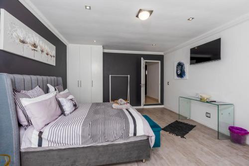 a bedroom with a large bed and a desk at Bed and Breakfast Villa Livadia in Cape Town