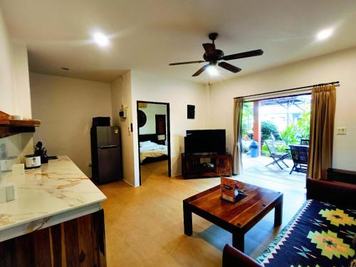 a kitchen and living room with a ceiling fan at Baan Tropicana in Mae Nam