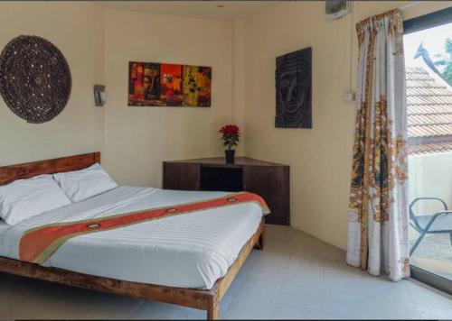 a bedroom with a bed and a window at Baan Tropicana in Mae Nam
