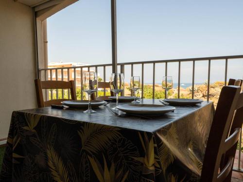 - une table avec des verres à vin et une vue sur l'océan dans l'établissement Bel appartement 1 chambre, parking, wifi, climatisation - FR-1-723-132, au Cap d'Agde