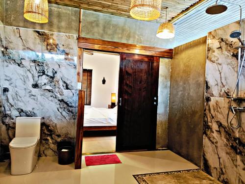 a bathroom with a door leading to a bedroom at Baan Tropicana in Mae Nam