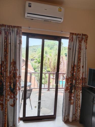 a sliding glass door with a view of a balcony at Baan Tropicana in Mae Nam