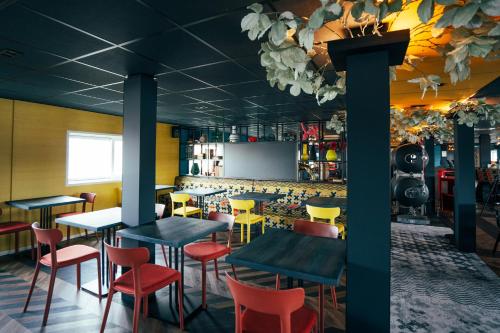 a restaurant with tables and chairs and a screen at Botel in Amsterdam