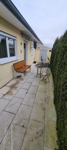 a bench sitting on a patio next to a house at Ferienwohnung Delja in Aulendorf
