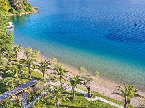 an aerial view of a beach with palm trees at Grecotel LUXME Daphnila Bay in Dassia
