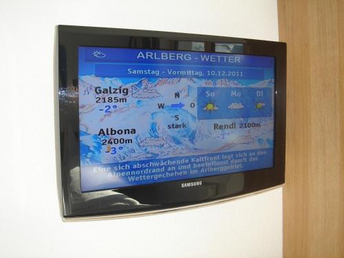 a television screen with a sign on a wall at Arlenweg in Sankt Anton am Arlberg