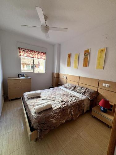 ein Schlafzimmer mit großem Bett und Fenster in der Unterkunft Apartamento vacacional cerca al mar - OROPESA DEL MAR in Oropesa del Mar