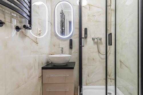 ein Badezimmer mit Waschbecken und Dusche in der Unterkunft Apartament Capri z widokiem na morze- Krynica Morska in Krynica Morska