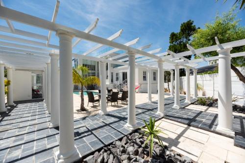 an outdoor patio with a white pergola at Bed and Breakfast Villa Livadia in Cape Town