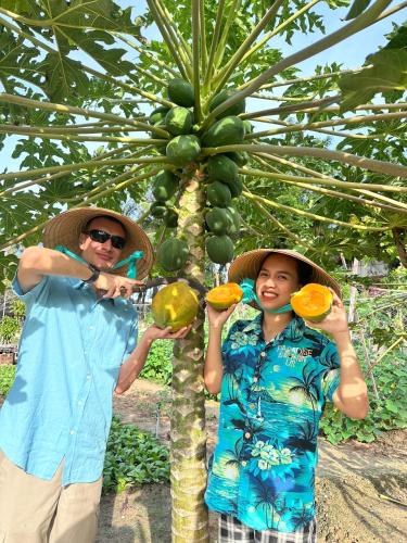 two people wearing hats standing next to a banana tree at Paradise Resort Doc Let - All Inclusive in Doc Let