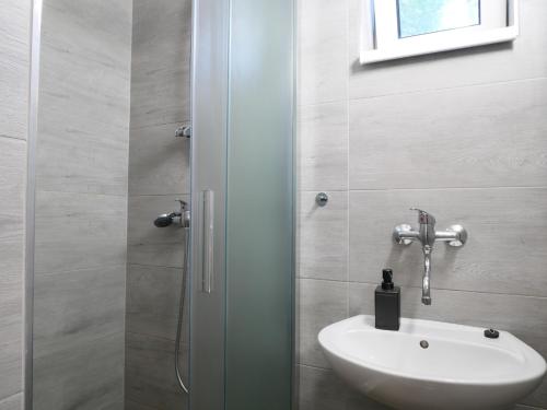 a bathroom with a white sink and a shower at Camping Rožnov in Rožnov pod Radhoštěm