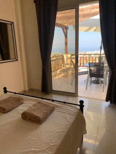 a bedroom with a bed with a view of a balcony at Park View Gardens H502 in Peyia