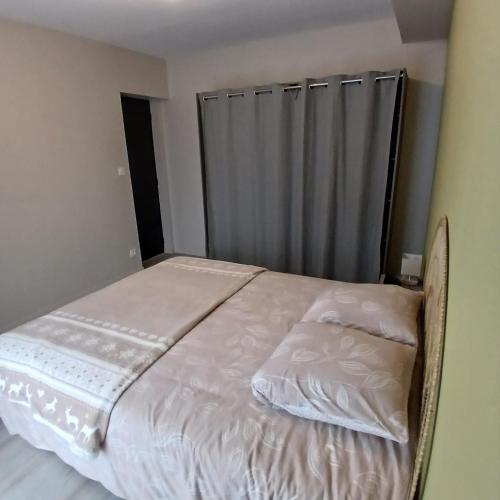 a bed with white sheets and pillows in a bedroom at Le Cat'Etoiles in Autun
