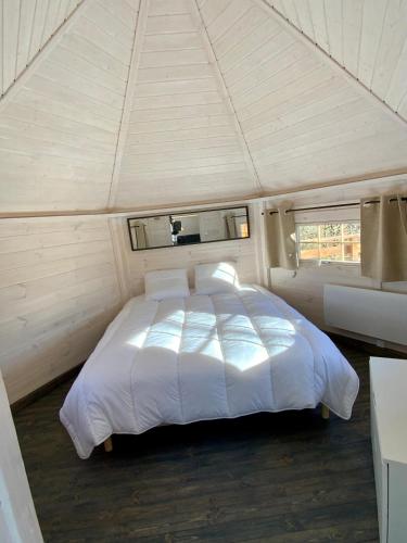 - une chambre avec un lit blanc dans une tente dans l'établissement La Cabane perchée du Grand Chêne, à Bongheat
