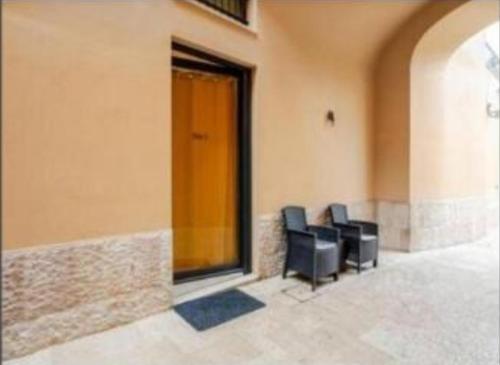 two black chairs sitting in the corner of a building at Room 3 Martini in Altamura