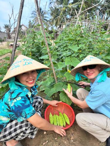 two women wearing hats and holding a basket of bananas at Paradise Resort Doc Let - All Inclusive in Doc Let